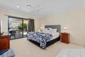 een slaapkamer met een bed en een glazen schuifdeur bij Relaxation & Space in a Canal Home in Banksia Beach