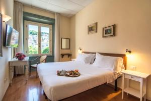 a bedroom with a bed with a tray of food on it at Hotel della Vittoria in Ancona