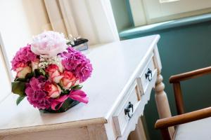 a bouquet of flowers sitting on top of a dresser at Hotel della Vittoria in Ancona