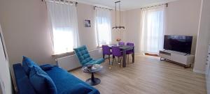 a living room with a blue couch and a table at Jessis Harz Appartements in Sankt Andreasberg