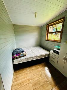 ein kleines Schlafzimmer mit einem Bett in einem Zimmer in der Unterkunft Cantinho aconchegante na Serra in Três Coroas