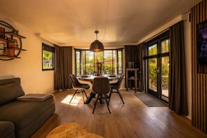 a living room with a table and chairs and a couch at 4pers Welness vakantiehuis in natuurrijke omgeving in Reutum