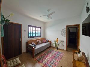 a living room with a couch and a ceiling fan at A Ver o Mar Guest House in Caraguatatuba