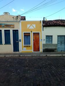 a yellow building with a red door on a street at Casa na Chapad Diamantina Andaraí - Igatu in Andaraí