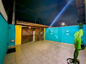 a cactus in a room with a blue and yellow wall at A Ver o Mar Guest House in Caraguatatuba