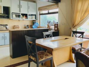 Una cocina con una mesa y sillas de madera. en 3 Bed Luxury House with Valley Views & Privacy, en Murree
