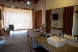 a hotel room with a sink and a bed at Gaviota Beachfront Room with Pool, Troncones in Troncones