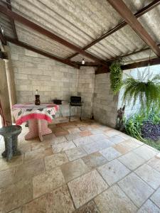 a patio with a table and a stone wall at Sobrado Beira da Mata in Pirenópolis