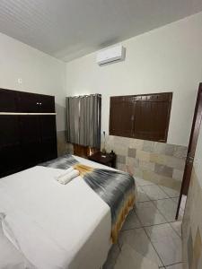 a bedroom with a large white bed and brown cabinets at Sobrado Beira da Mata in Pirenópolis +19 photos