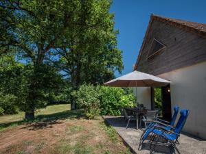 a patio with a table and chairs and an umbrella at Lac Bleu huis nr 13 in Le Bourg