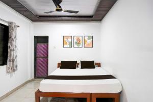a bed in a room with a ceiling fan at Hotel O Raj Resort in Sopāra