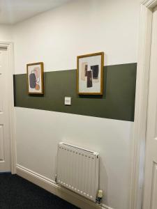 a room with green and white walls and a radiator at The Residency 4 bed home in Liverpool free parking in Litherland
