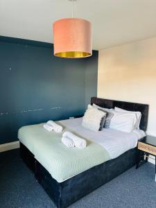 a bedroom with a large bed with towels on it at The Residency 4 bed home in Liverpool free parking in Litherland
