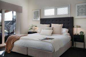 a bedroom with a large bed with a large window at Oblique in Hepburn Springs