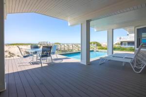 a deck with a table and chairs and a pool at Spectacular 8 Bedroom Oceanfront Hamptons Beach House, Your Castle By The Sea ! in Remsenburg