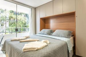a bedroom with a bed with two towels on it at Flat Aconchegante c/ Piscina em Carneiros - FH105 in Tamandaré +29 photos