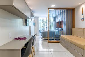 a kitchen and living room with a table and chairs at Flat Aconchegante c/ Piscina em Carneiros - FH105 in Tamandaré