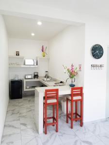 eine Küche mit zwei roten Barhockern und einer Theke in der Unterkunft Villa Alebrije Cozumel in Cozumel + 29 Fotos