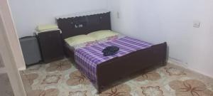 a small bed in a room with a purple at Ashila hawmat ginawa in Asilah