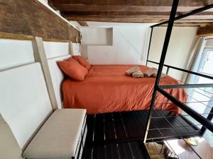 una camera con un letto in una piccola stanza di La Mezzanine Bourgogne a Orléans