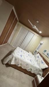 a bed in a small room with a window at Jacuipe beach house in Camaçari