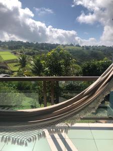 eine Hängematte auf einem Balkon mit Blick auf das Tal in der Unterkunft Ariticum Chalés in Lagoa Sêca + 4 Fotos