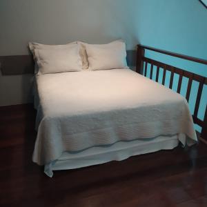 a bed with white sheets and pillows in a room at Ariticum Chalés in Lagoa Sêca +4 photos