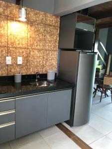 eine Küche mit einem Kühlschrank aus Edelstahl und einer Spüle in der Unterkunft Ariticum Chalés in Lagoa Sêca