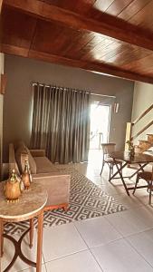 ein Wohnzimmer mit Sofa und Tisch in der Unterkunft Ariticum Chalés in Lagoa Sêca