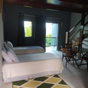 ein Schlafzimmer mit Bett, Schreibtisch und Fenster in der Unterkunft Ariticum Chalés in Lagoa Sêca