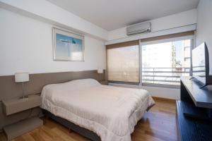 a bedroom with a bed and a large window at Complejo Quartier San Telmo & Spa in Buenos Aires +41 photos