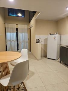 a kitchen with a table and a refrigerator at Loft Sp in San Pedro +2 photos