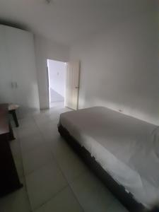 a bed in a white room with an open door at Rey SALOMÓN SALJA in Barranquilla