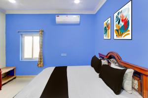 1 dormitorio con paredes azules y 1 cama en Hotel O Classic luxury Rooms, en Warangal