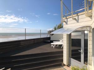 a building with a balcony with a view of the beach at 1-bedroom apartment with view of private beach in Agon Coutainville