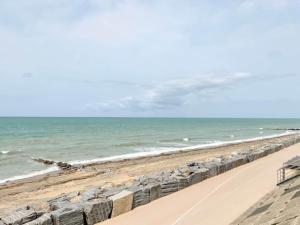 a beach with a row of rocks and the ocean at 1-bedroom apartment with view of private beach in Agon Coutainville +15 photos