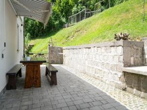 a patio with two benches and a stone wall at Green Area Apartments Krem ar - GroundFloor Apartment With Terrace in Homer