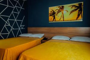two beds in a room with palm trees on the wall at Hotel Condina Pereira in Pereira +84 photos