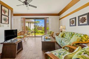a living room with a couch and a tv at Kiahuna Plantation 322 in Kipu