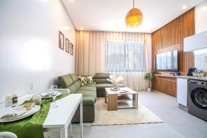 a living room with a couch and a table at Cactus Apartment - Walk to Surf Beaches, Rooftop View, Remote Work, Free Parking, AC in Agadir nʼ Aït Sa