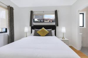 une chambre avec un grand lit blanc et une fenêtre dans l'établissement The Terrarena - Family Stay near Shopping & Eateries, à Brisbane 10 autres photos