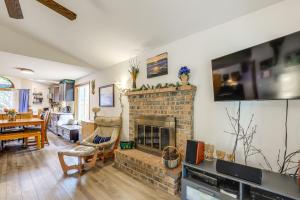 a living room with a brick fireplace with a flat screen tv at Tranquil Home with Patio and Fenced Yard in Vancouver! in Evergreen