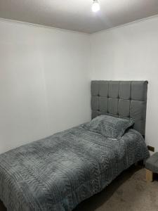 ein Schlafzimmer mit einem Bett mit einer grauen Bettdecke in der Unterkunft apartment Santiago downtown Paseo Bulnes in Santiago
