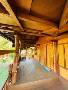 an open porch of a house with a wooden ceiling at Medya homestay in Pulau Sarang