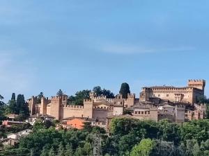 a large castle on top of a hill at Large apartment in a stone farmhouse in Fiorenzuola di Focara