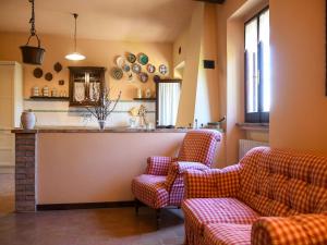 a living room with two couches and a kitchen at Large apartment in a stone farmhouse in Fiorenzuola di Focara