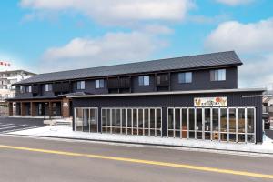 a black building on the side of a street at 遊学の宿いさみや 