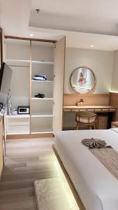 a bedroom with a bed and a table and a mirror at MODERN 2 BEDROOM LAVAYA OAKWOOD APARTMENT, Nusa Dua in Nusa Dua +9 photos