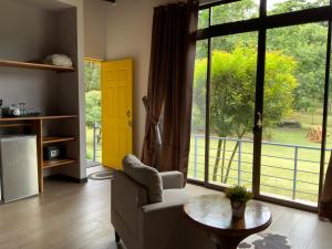 a living room with a table and a large window at YerbaBuena Lodge in Monteverde Costa Rica