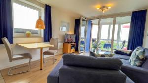 una sala de estar con un sofá y una mesa en Haus Horizont I HZ04, en Sahlenburg